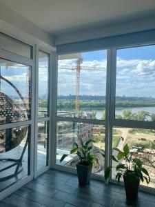 キーウにある4 rooms apartment with a view to the Dnieper Riverの水辺の景色を望む大きな窓が備わる客室です。