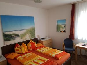 a bedroom with two beds and a desk and a window at Pension Gästehaus Elfriede Baltrum in Baltrum