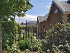 une maison avec un portail en face d'une maison dans l'établissement Clarens Mountain Sage Holiday House, à Clarens