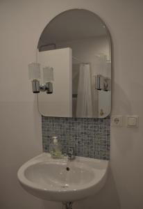 uma casa de banho com um lavatório e um espelho em Apartamenty u Majki 2 em Frydman