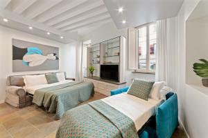 罗马BMGA l ViaPaola43 Palace的房间里有两张床、一张沙发和一台电视