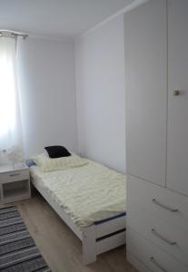 a white bedroom with a bed and a white cabinet at Apartamenty u Majki 2 in Frydman