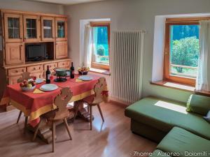 uma sala de estar com uma mesa e um sofá em 7home em Auronzo di Cadore