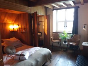 1 dormitorio con 1 cama con cabecero de madera y ventana en B&B kasteel Ammersoyen, en Ammerzoden