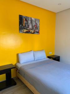 1 dormitorio con 1 cama con pared amarilla en Le Calme a Temara, en Temara
