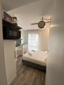 a bedroom with a bed and a clock on the wall at Studio Gare Part Dieu in Lyon
