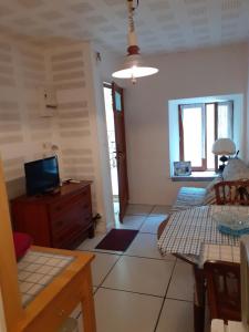 a living room with a television and a table at Petit Gîte des Augustins in Monflanquin