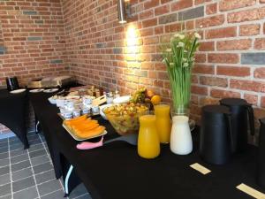 a black table with a bowl of fruit and juice at B&B DeSo in Zonnebeke