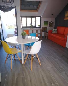 a living room with a table and chairs and a couch at Bnbook Medea Apartments in Fuengirola