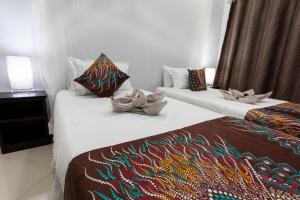 duas camas num quarto de hotel com toalhas em Nzubo Experience em Livingstone