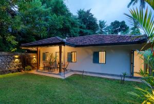a small house with a patio in the yard at STUTHI VILLA in Ahangama
