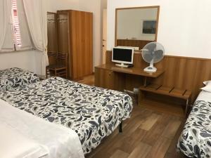 1 dormitorio con 2 camas y escritorio con ordenador en Hotel Lodi en Roma