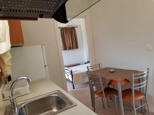 una pequeña cocina con mesa y fregadero en Domaine Papakonstantis Apartments To Let, en Skoutari