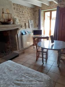 a living room with two tables and a fireplace at Chambre d'hôte du Plessis in Beaurepaire