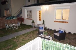 Casa blanca con mesa y sillas en el patio en Maison de standing avec jardin à 200m de la plage, en Berck-sur-Mer
