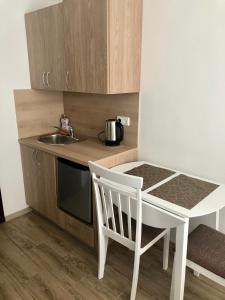 a small kitchen with a sink and a table and a chair at Summer spot Nida in Nida
