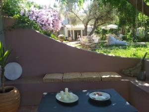 a patio with a table and a bench and a garden at Ostria in Agios Nikitas