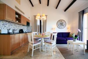 Hapimag Apartments La Madrague في لا مادراج: مطبخ وغرفة طعام مع طاولة وكراسي