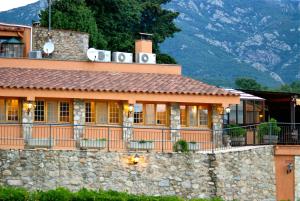 a building with a stone wall in front of it at Restaurante y Alojamiento Can Mach in Tapis