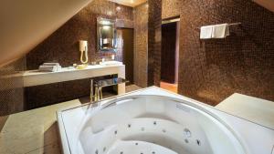 a large bathroom with a tub and a sink at Hotel Bulwar in Toruń