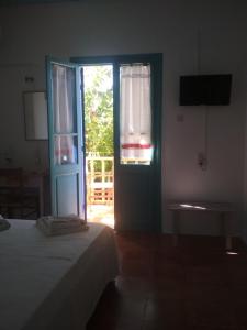 a bedroom with a bed and a door with a window at Ostria in Agios Nikitas