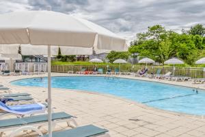 una piscina con sillas y sombrilla en Le Vallon, en Branville