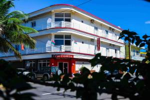 ein großes weißes Gebäude mit Balkon auf einer Straße in der Unterkunft Hotel Victoria in Diego Suarez