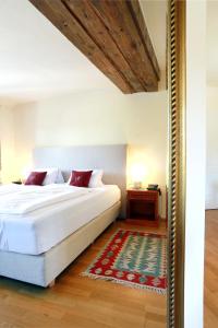 a bedroom with a white bed and a rug at Renaissancehotel Raffelsberger Hof B&B in Weissenkirchen in der Wachau