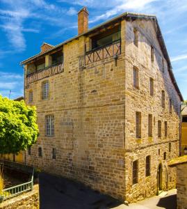 - un ancien bâtiment en briques avec un balcon au-dessus dans l'établissement Chambre d'hôtes Conquans, à Figeac