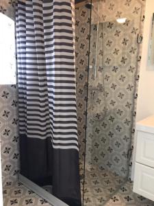 a shower with a black and white shower curtain at Annagården Österlen in Kivik +35 photos