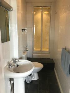 a white bathroom with a sink and a toilet at Crystal House in Barmouth