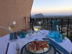 a table with a plate of food and wine glasses at Casa Aguilera in Benissa