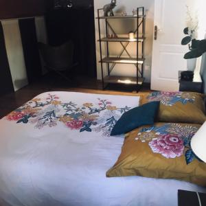 a bed with flowers on it with two pillows at Maison atypique in Brando