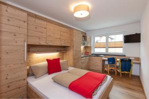 a bedroom with a bed with a wooden wall at GIGGI Tenne Studios in Sölden