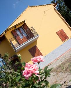 uma casa amarela com uma flor à frente dela em La Gazza em Viterbo