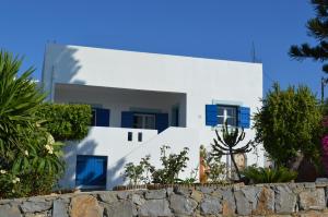 Casa blanca con ventanas azules y pared de piedra. en Villa SK en Sissi