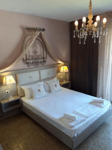 タソスにあるVila Zanetのベッドルーム(シャンデリア付きの白い大型ベッド1台付)