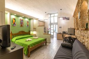 a bedroom with a green bed and a kitchen at Green house in Orvieto