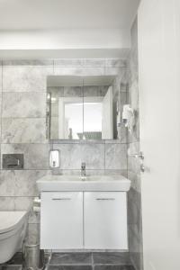 a white bathroom with a sink and a toilet at Emin Residence in Istanbul