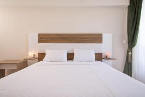 1 dormitorio con 1 cama blanca grande y 2 almohadas blancas en Emin Residence, en Estambul