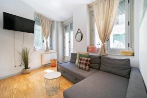 a living room with a couch and a tv at Apartamentos Moratín Las Letras in Madrid