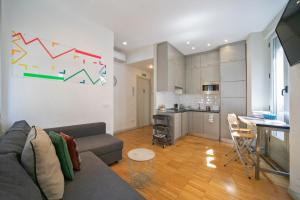 a living room with a couch and a table and a kitchen at Apartamentos Moratín Las Letras in Madrid