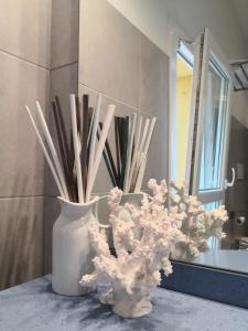 two white vases sitting on a counter in a bathroom at Casa 28 in Bologna