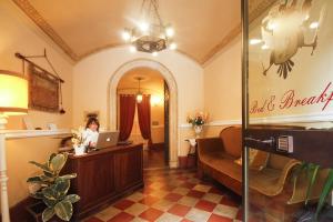 a woman sitting at a desk with a laptop in a salon at Antica Residenza Cicogna in Siena