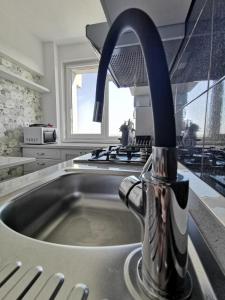 a sink with a faucet in a kitchen at New York Apartament in Suceava