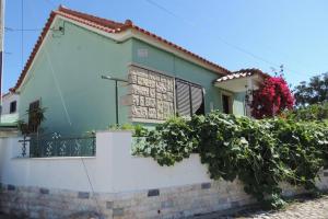 une maison verte avec une clôture blanche dans l'établissement BLISS BOHO HOUSE, à Sintra