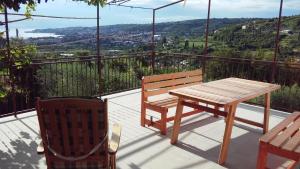 een houten tafel en stoelen op een balkon met uitzicht bij apartma med oljkami in Portorož