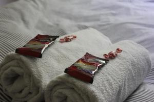 a pair of folded towels on a bed with roses at 1-Bedroom Apartment with Sauna in Heinola