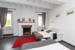 een witte slaapkamer met 2 bedden en een open haard bij Gorgeous Trastevere loft on the river in Rome