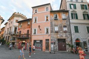 grupa ludzi idących ulicą z budynkami w obiekcie Gorgeous Trastevere loft on the river w Rzymie